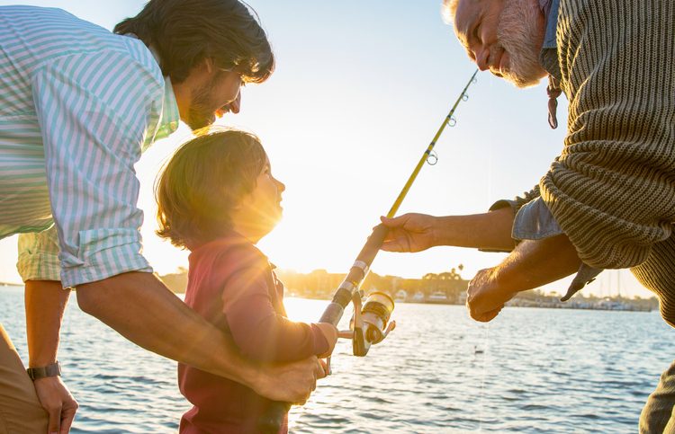 little boy fishing with dad and grandpa